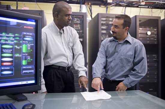 computer workers standing in front of network servers
