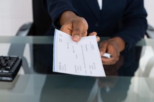 Person's Hand Giving Check