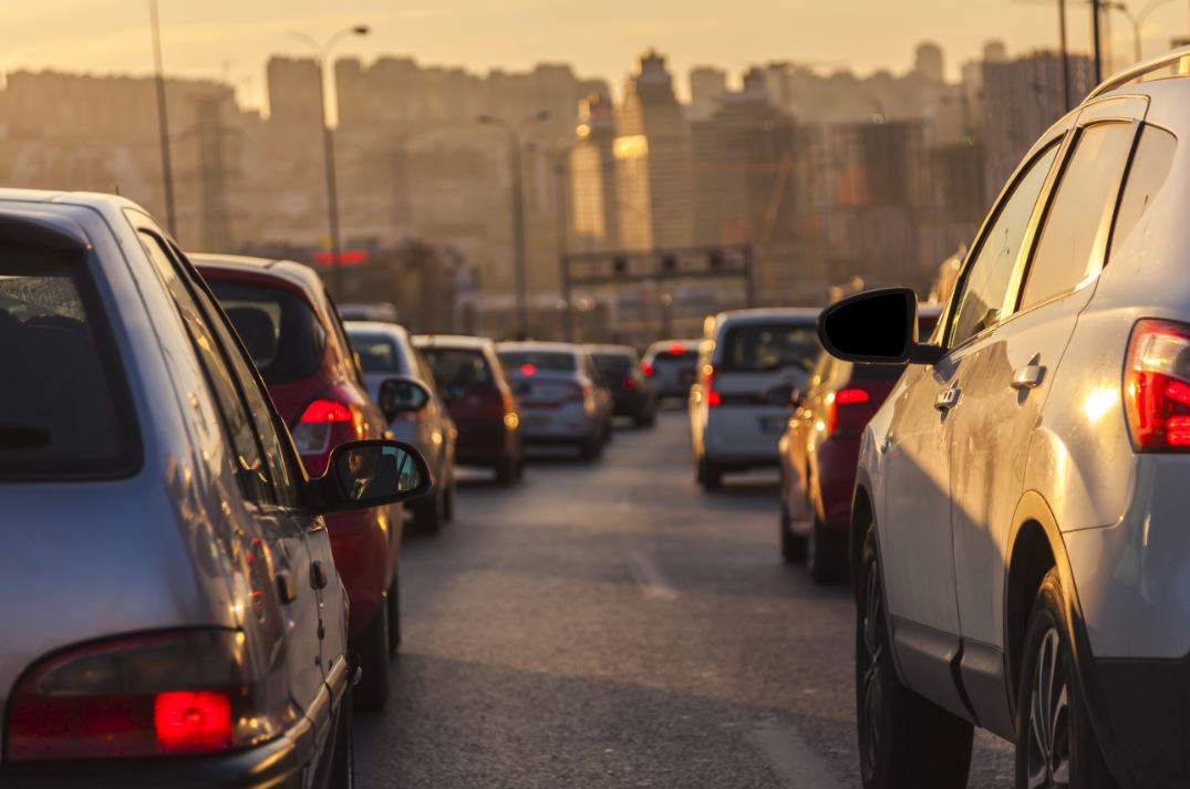 An image showing cars in rush hour traffic in an urban area.