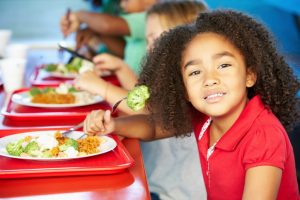 Smiling student eating her lunch.