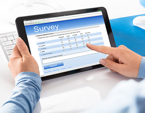 Hands holding a tablet computer and completing a survey
