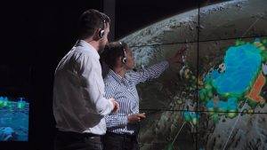 Two meteorologists tracking a storm with satellite images.