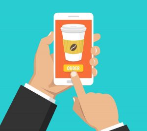 Person holding mobile phone and ordering coffee on an app.