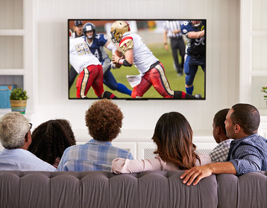 A group of friends and family watching a football game on TV