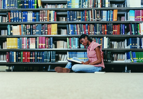 Student reading a book in a library