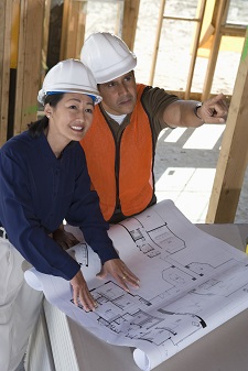 Architect and construction manager looking at blueprints