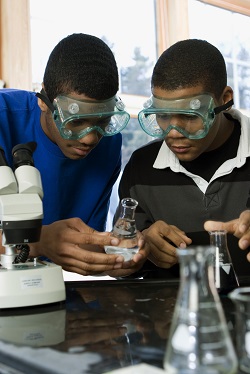 two high school boys working on a chemistry experiment