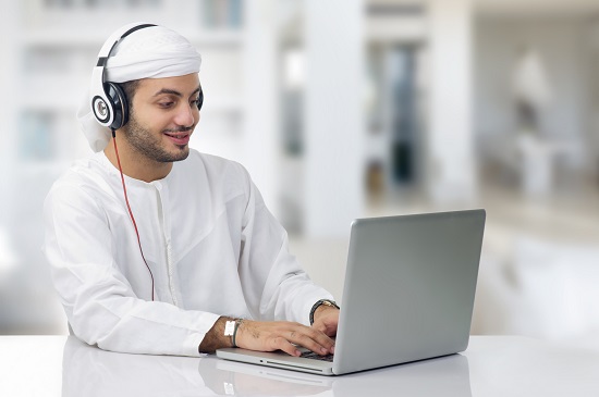 Man with headphones on a computer