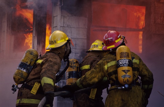 Firefighters entering a burning building