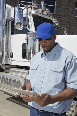 Truck driver standing in front of a truck
