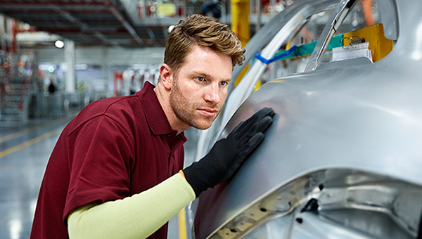 Assembler inspecting car body.