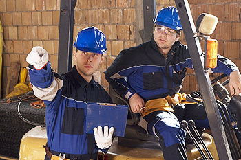Two men operating construction equipment