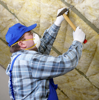 Man fastening insulation to a wall