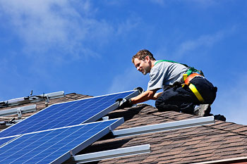 Man installing solar panels on a roof