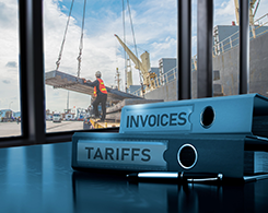 Notebooks containing invoices and tariff rates on desk in office building