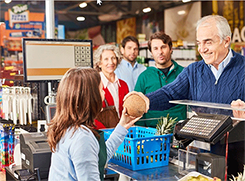 Older gentleman purchasing groceries at the cash register