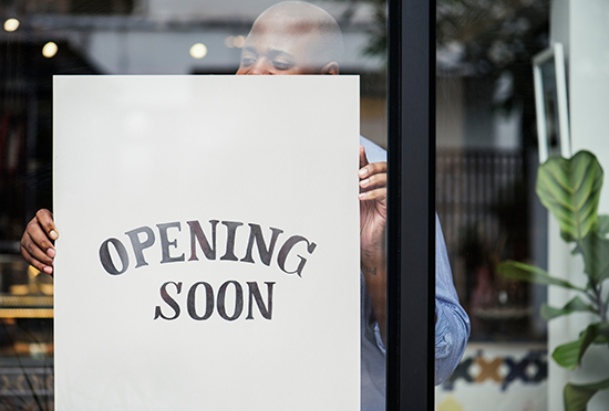 Photo of a sign in a store window that says opening soon