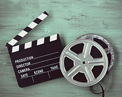 Clapperboards  and two film reels on a painted board