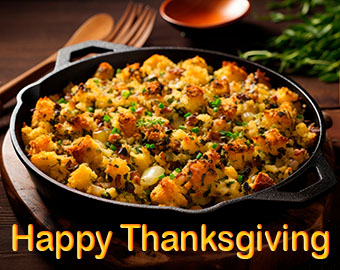 Cast iron skillet of oyster stuffing. Text reads Happy Thanksgiving. 