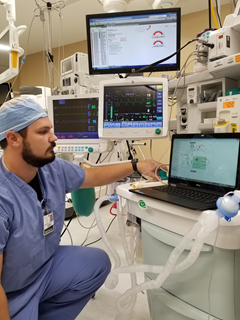 Medical equipment repairer working on medical equipment in a hospital room.