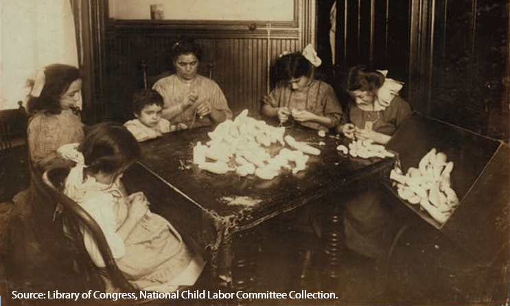 In 1908, children and their mother work making doll legs after school and often until 10 pm, New York.