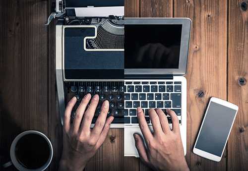 Split image of a person typing on half a typewriter and the second half being a computer