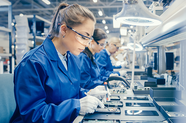 A woman in a high-tech factory assembling a smartphone.