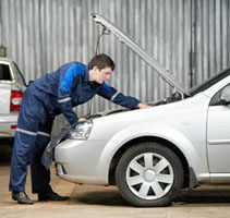 Man working under hood of car