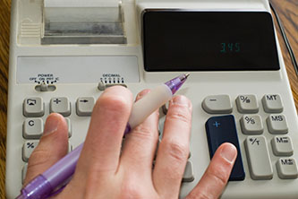 a worker using a 10-key calculator