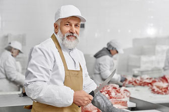 Male butcher sharpening knife at a butcher shop.