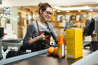 Female cashier scanning food at a register in a market.