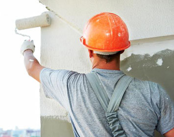 Worker painting a building