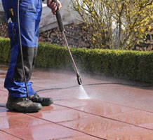 Person pressure washing a patio