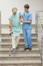 Nurse assisting patient with walker down the stairs