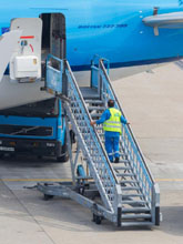 Worker climbing stairs to airplane