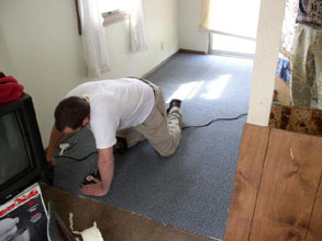 Man crawling while installing carpet