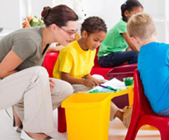 Teacher crouching to work with young student