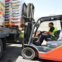 Worker using forklift to move pallets