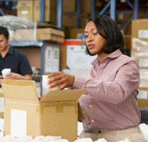 Woman inspecting an item while working in a warehouse