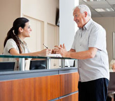 Man talking to a front desk receptionist