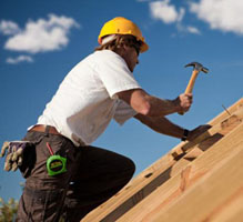 Man kneeling while building a roof