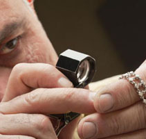 Man using magnifier to examine jewelry