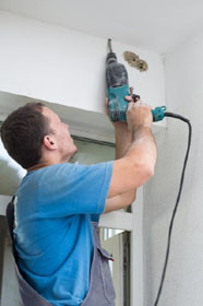 Worker drilling hole in ceiling