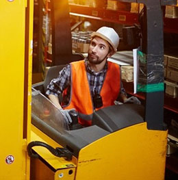 Worker driving forklift