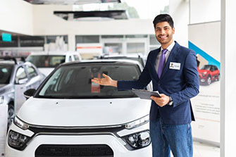 Man standing in front of and gesturing towards car