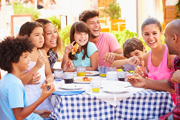 Families with parents and children eating at an outdoor restaurant
