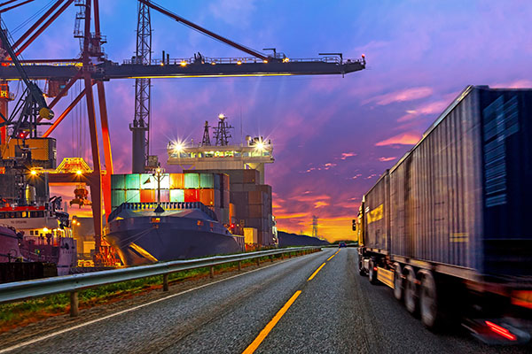 Truck driving on road next to port